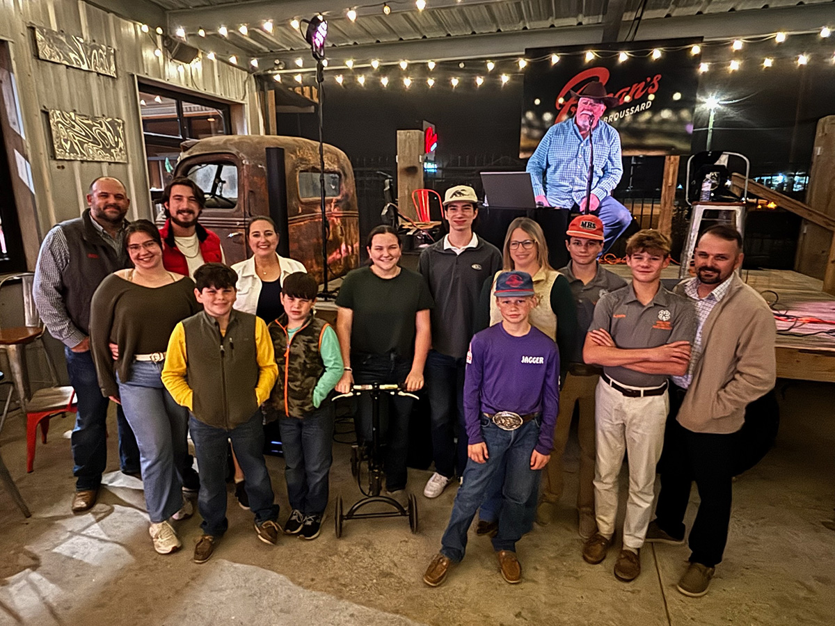 group gathered at event around antique truck